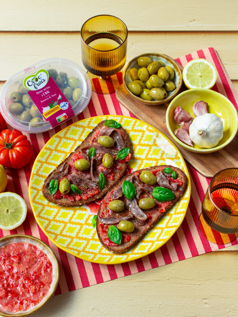 Deux parts de bruschetta avec des légumes et des olives