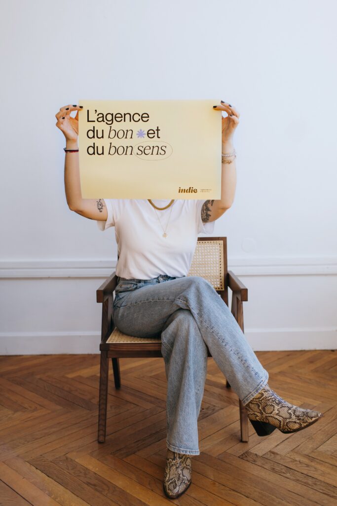 Femme tenant une affiche avec un slogan assise sur une chaise