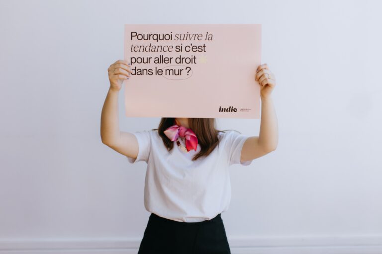 femme qui tient une affiche avec un slogan de l'agence indie