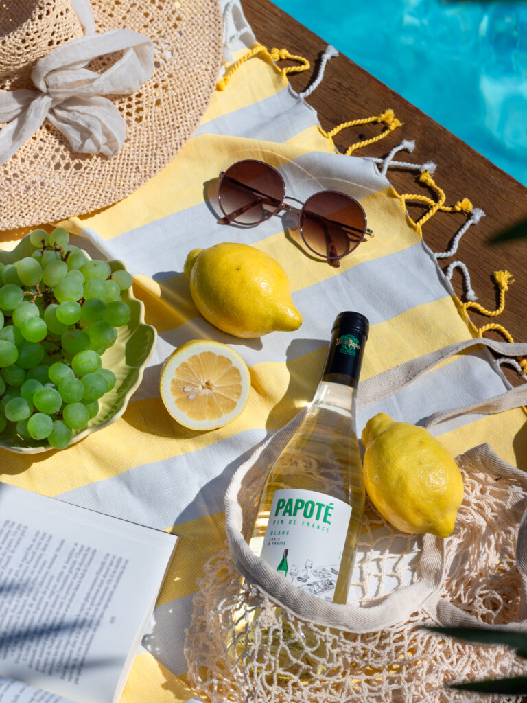 Bouteille de vin de la marque Papoté, client de l'agence Indie, au bord d'une piscine en plein été